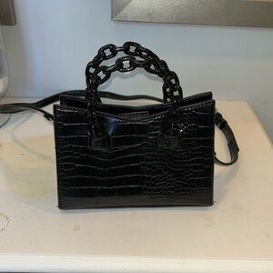 Black purse with detachable strap and snap closure